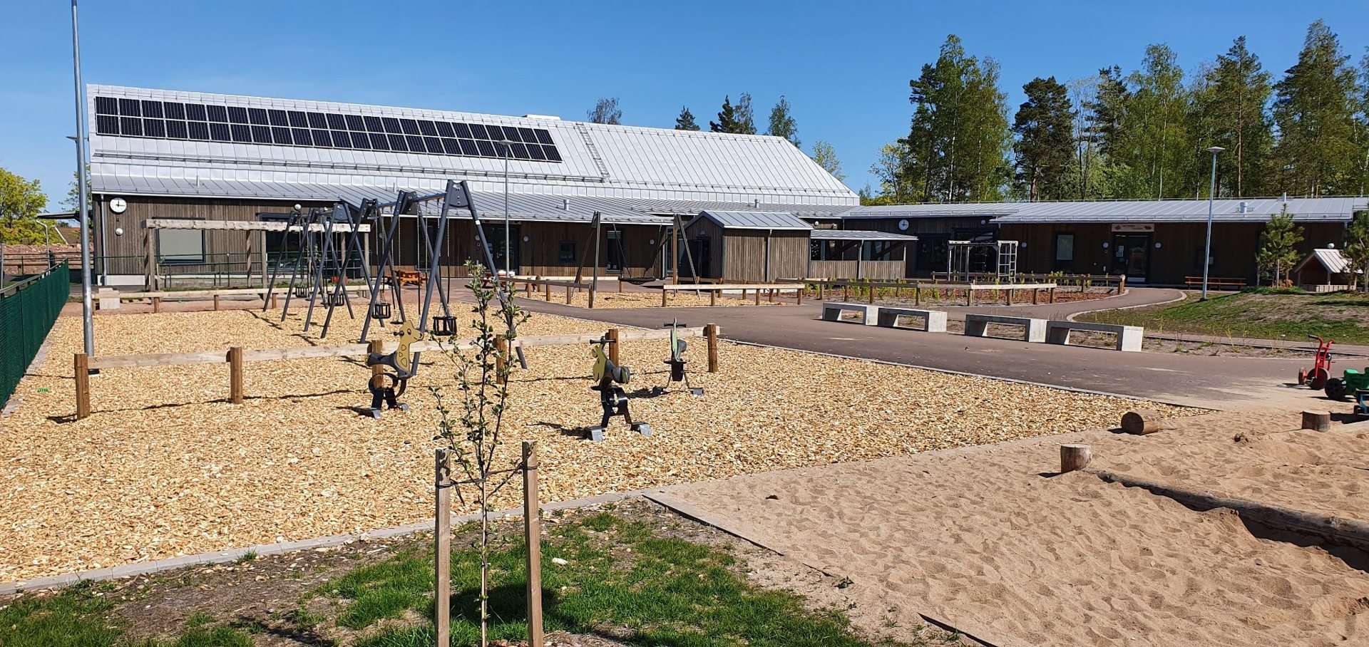 Lekplats med gungor framför daghemmet i Lemland