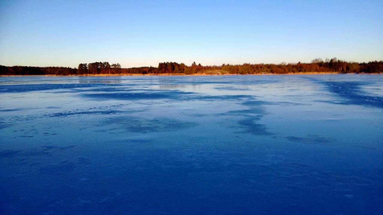 Isbelagd fjärd i kvällsljus