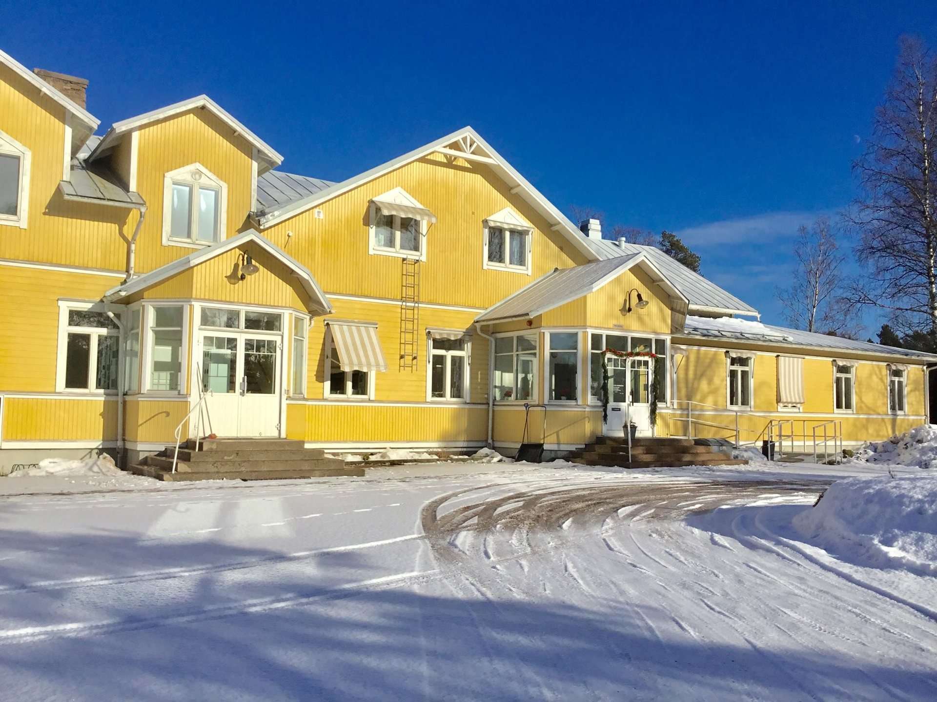 Det gula kommunhuset i Söderby i snö och sol